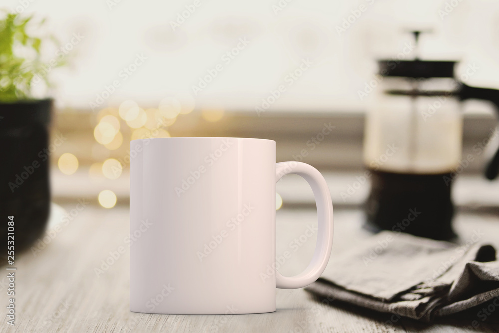 White mug infront of a cafetier and newspaper. Perfect for businesses selling mugs, just overlay your quote or design on to the image.