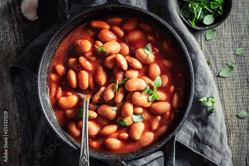 Tasty baked beans with garlic and fresh tomatoes photo