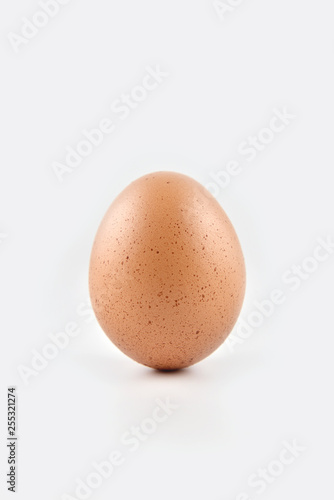 Chicken egg standing vertical isolated on white background..