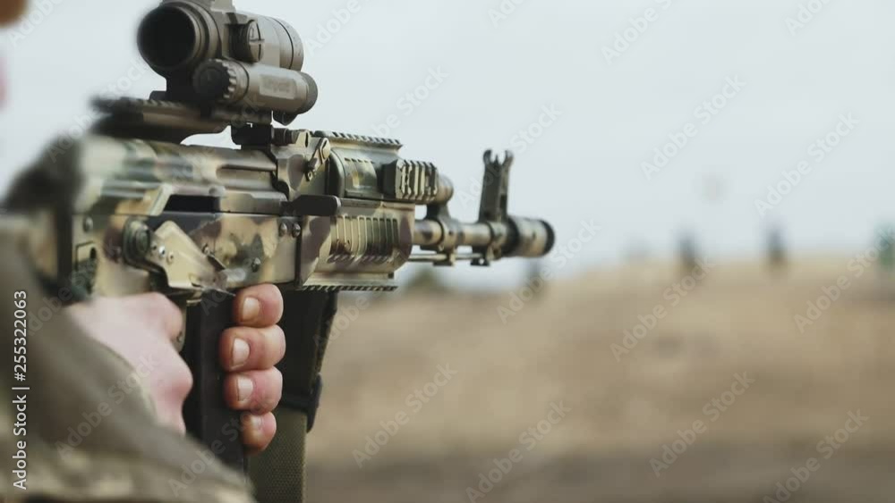 Ranger shooting from assault rifle with optical sight in a range in slo-mo Ranger shooting from assault rifle with optical sight in a range in slo-mo