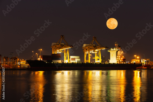 Super moon and cargo Containers loading Shipping by crane at night time.