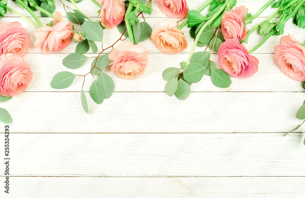 Flowers composition background . Pink flowers ranunkulus and eucalyptus leaves frame  on white wooden background. Top view. Copy space. Flat lay