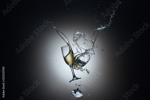 Collision of champagne glasses with shattered glass and champane splash