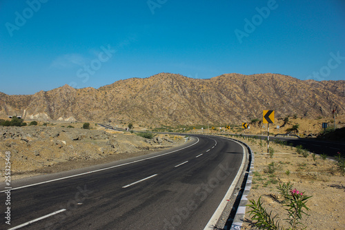 Mount Abu scenic road view with asphalt road and road signs, with mountain view and blue sky background.