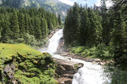 View from afar on one of the highest cascades of waterfalls in Europe - Krimmlsky waterfall . Austria.