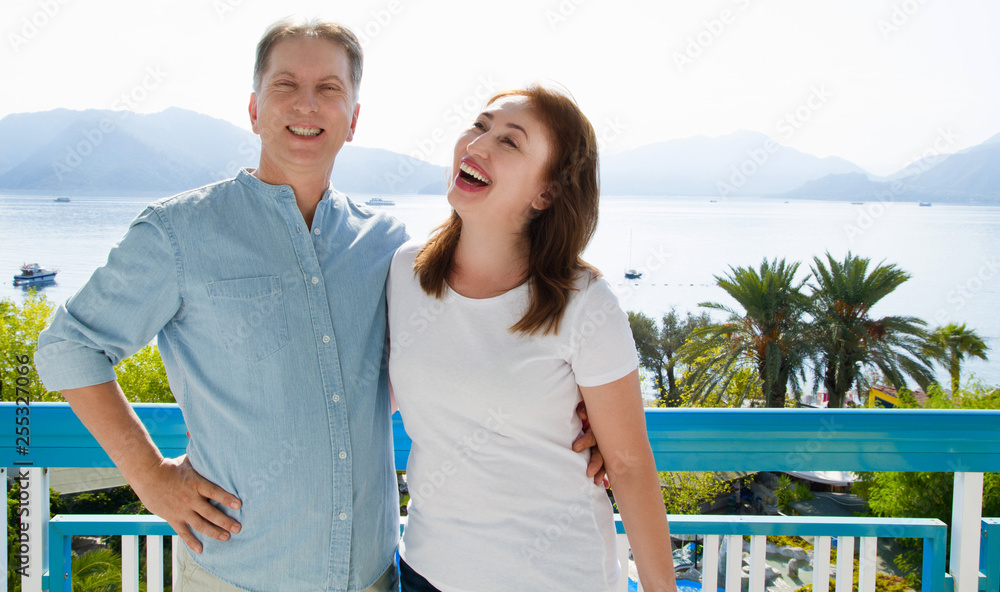 Naklejka premium Summer family vacation. Happy middle aged couple having fun on travel holidays weekend. Sea and beach background. Copy space.