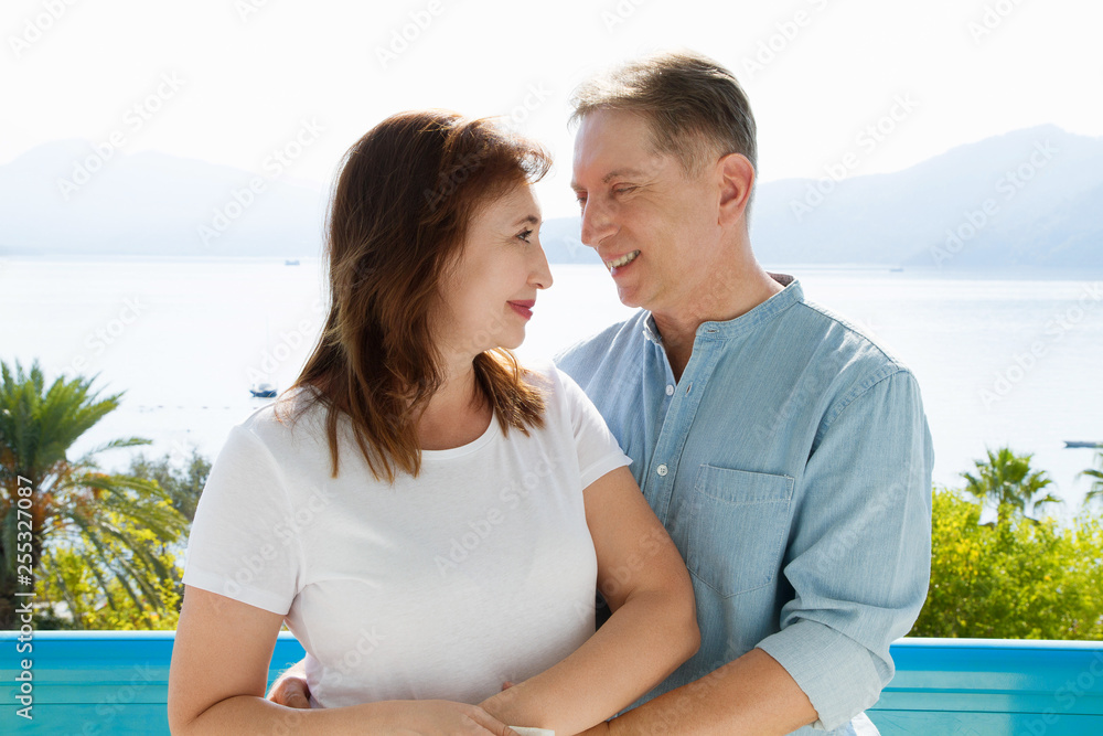 Summer family vacation. Happy middle aged couple having fun on travel holidays weekend. Sea and beach background. Copy space. Summer family vacation. Happy middle aged couple having fun on travel holidays weekend. Sea and beach background. Copy space.