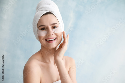 Woman with under-eye patches on light background