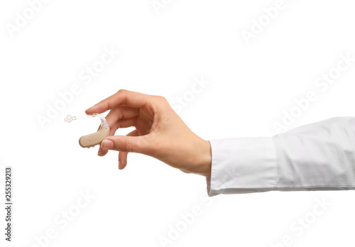 Female hand with hearing aid on white background