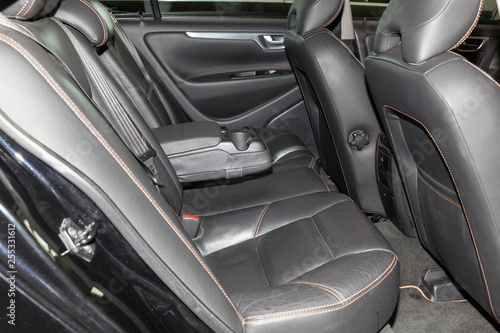 Clean after washing the rear passenger seats of matte black genuine leather inside the interior of an expensive sedan, preparation before selling the car. © Aleksandr Kondratov
