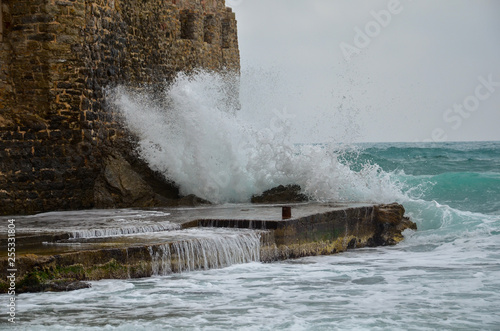 waves of the sea beating on the wall of the fortress. storm and high waves. strong wind and rocks photo