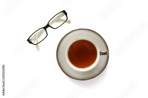 Eye glasses and a cup of tea on white background