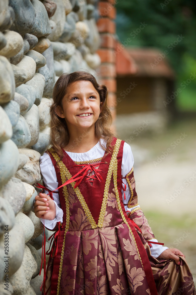 Girl in medieval attire near the old castle.