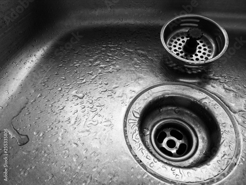 Close up of sink drain with water droplets