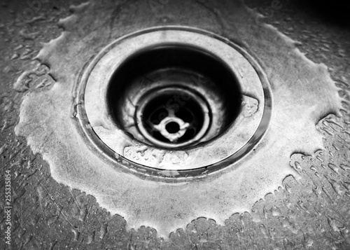 Close up of sink drain with water droplets