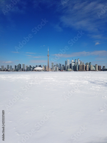 Toronto city skyline seen from toronto Islands over frozen lake Ontario