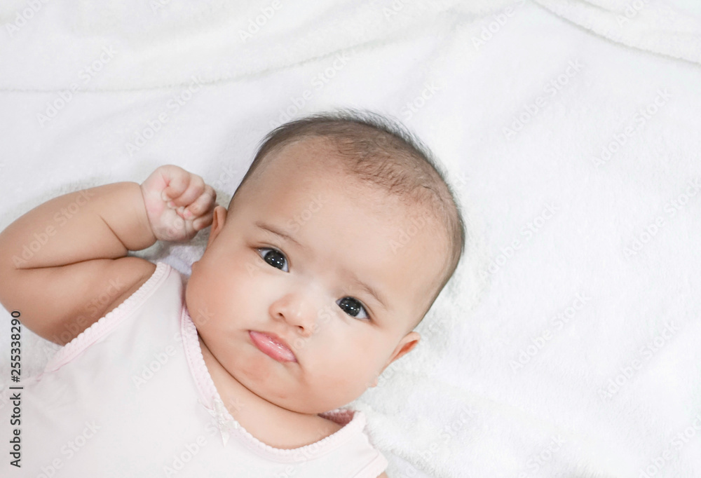 Asian newborn baby girl lying down on white bed Asian newborn baby girl lying down on white bed