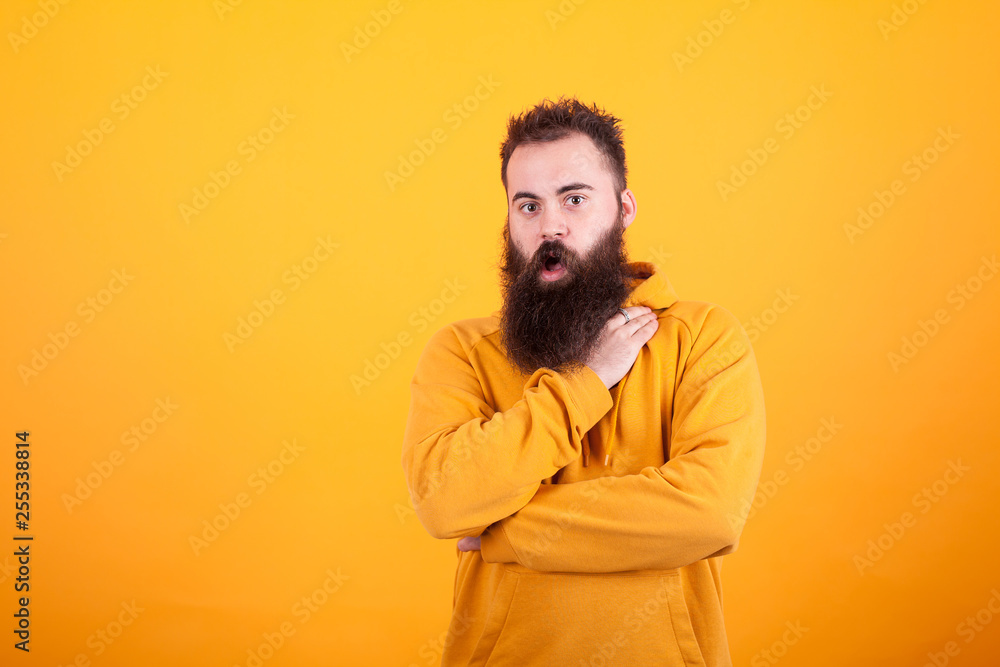 Portrait of beautiful bearded hipster looking amazed over yellow background Portrait of beautiful bearded hipster looking amazed over yellow background