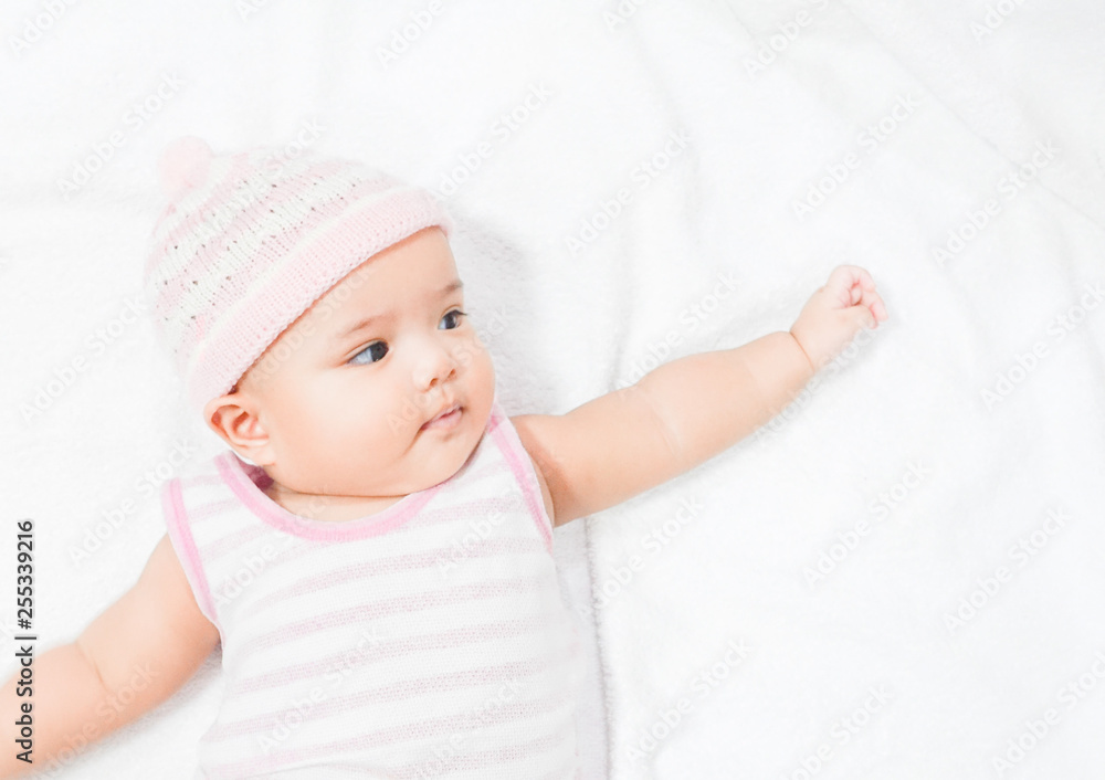 Asian baby wear pink knitting hat on white towel background