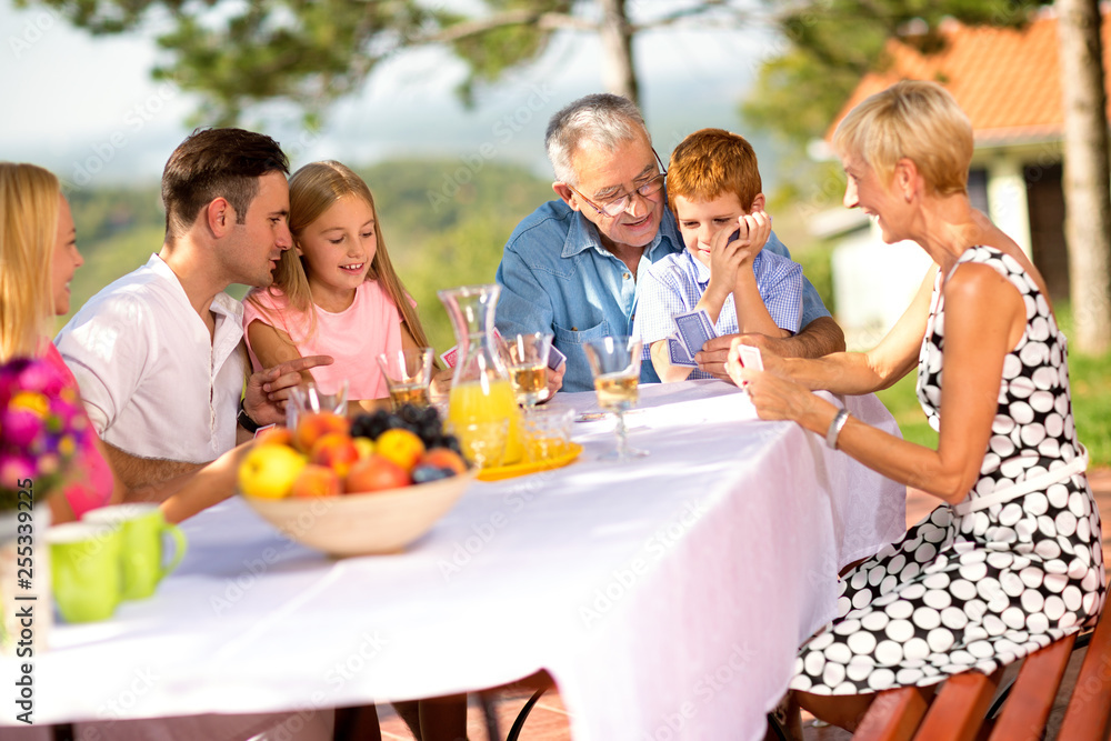 Happy family sitting at table outdoor. Happy family sitting at table outdoor.