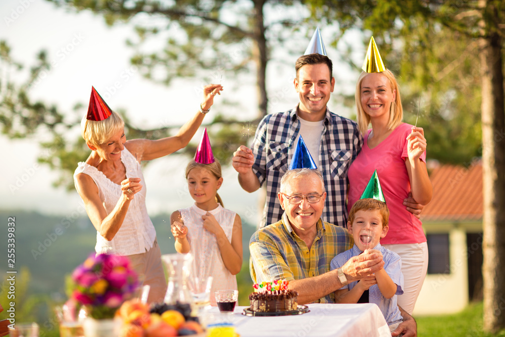 Fototapeta premium Portrait of a family in party hats and sprinklers.