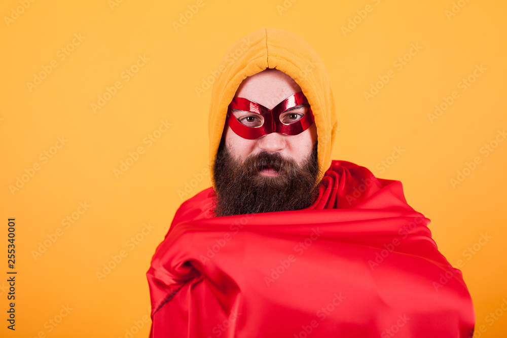 Fototapeta Brodaty superbohater z czerwoną maską pokazano jego czerwona peleryna na żółtym tle
