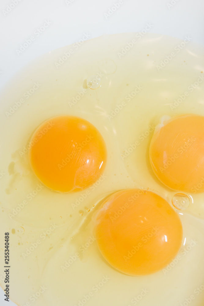 Three broken chicken eggs in a white mixing bowl Three broken chicken eggs in a white mixing bowl