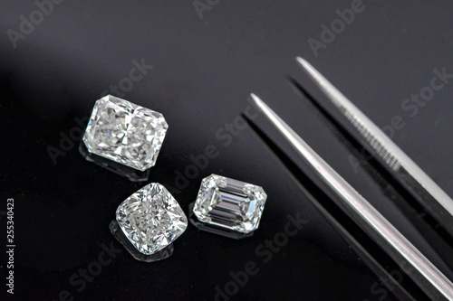 Multi shape of fancy diamonds with tweezers on black background