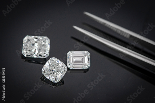 Multi shape of fancy diamonds with tweezers on black background