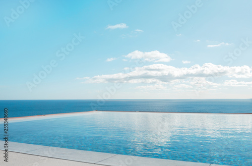 Luxury swimming pool in front of the sea. Swimming pool with beautiful sea and sky view. © steftach