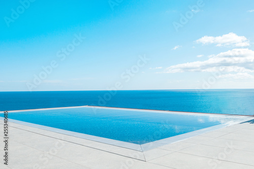 Luxury swimming pool in front of the sea. Swimming pool with beautiful sea and sky view. © steftach