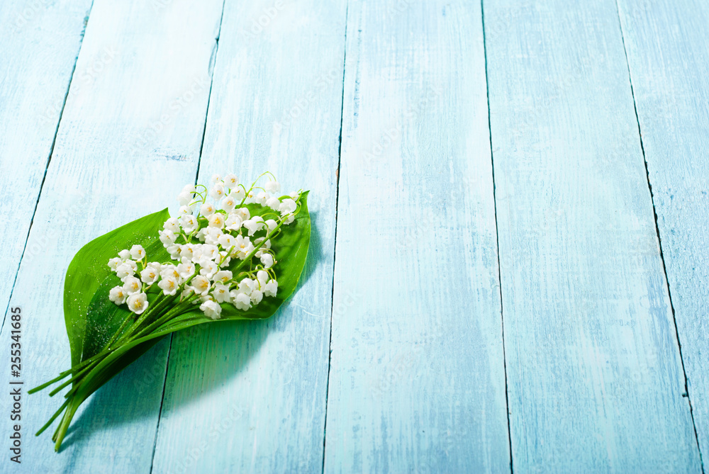 lily of the valley flowers bunch on blue painted wood table background