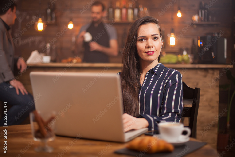 Attractive businesswoman looking at the camera in a vintage coffee shop Attractive businesswoman looking at the camera in a vintage coffee shop