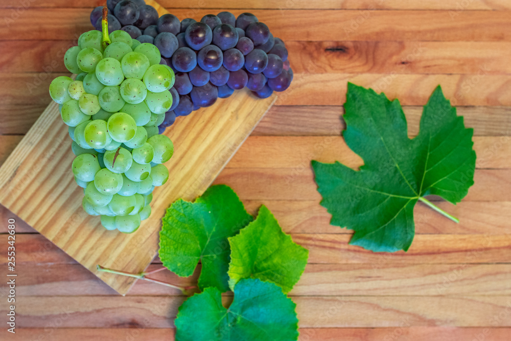 Wine background, bunch red and white grapes, cork, corkscrew, wine leaves, grapes on vintage background, wine concept. Top view on a wooden board. Wine background, bunch red and white grapes, cork, corkscrew, wine leaves, grapes on vintage background, wine concept. Top view on a wooden board.