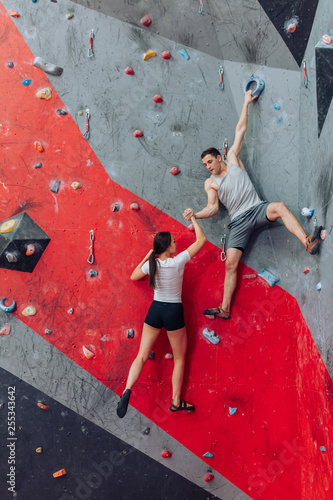 Strong man trying to lift climbing girl. Hand with tense muscles. Man attempting to help woman without experiment.