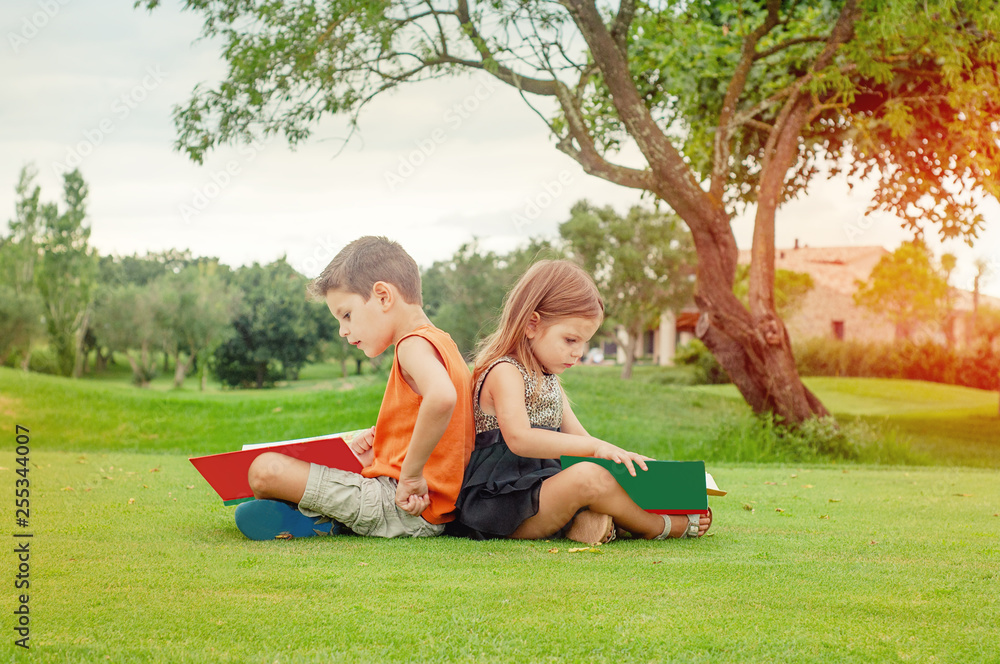 Fototapeta premium Children reading books in the park.