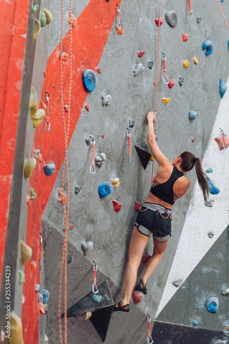 strong ambitious girl attending climbing classes. full length rare view photo. copy space