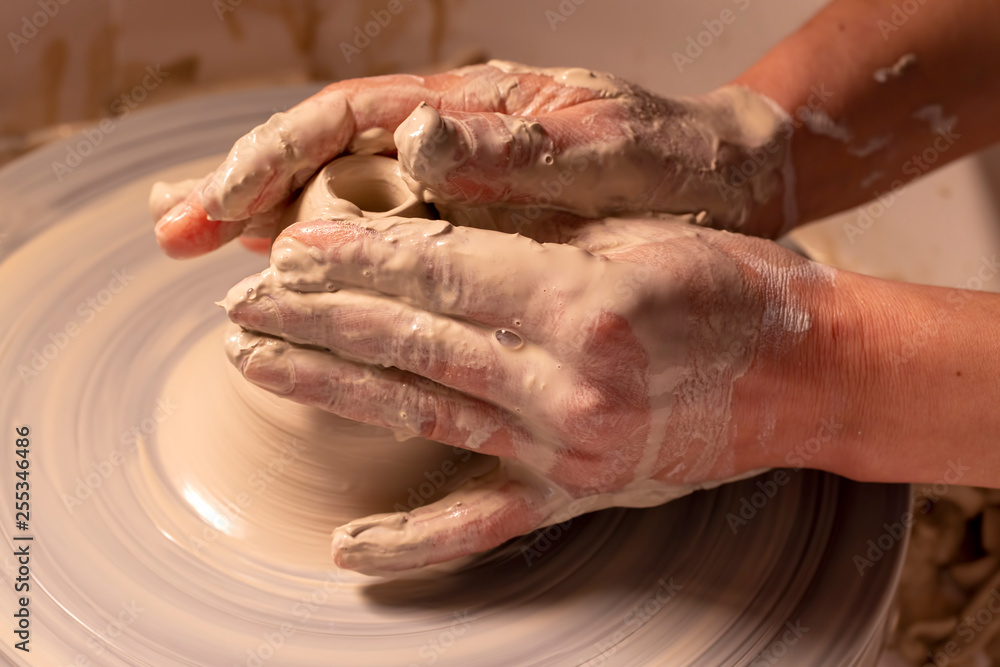 Professional potter making bowl in pottery workshop, studio.