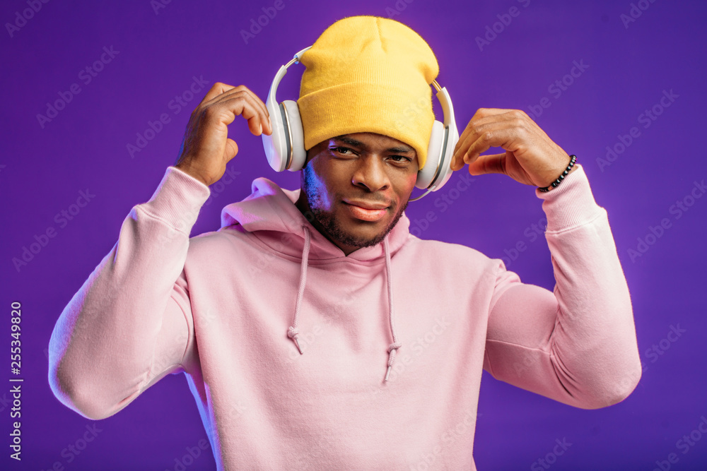 Studio portrait of handsome young man of African ethenity and headphones, enjoying listening to intresting audiobook. Studio portrait of handsome young man of African ethenity and headphones, enjoying listening to intresting audiobook.