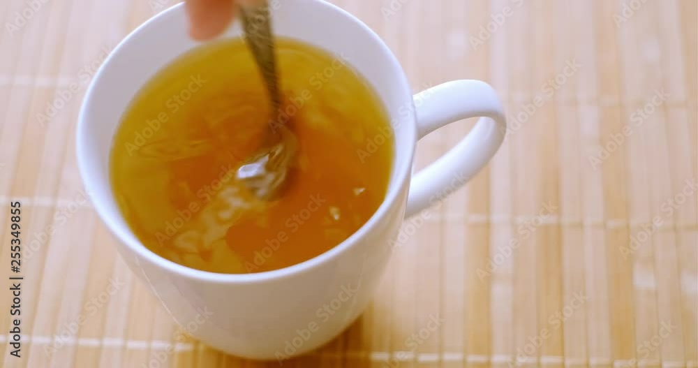 Stirring a cup of hot tea isolated Stirring a cup of hot tea isolated