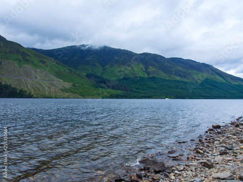 Am Ufer eines Sees im schottischen Highland bei bewölktem Himmel
