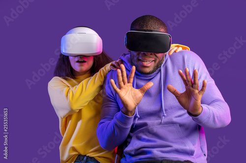 3d technology, virtual reality, gaming, entertainment and people concept - scared mixed race friends in virtual reality headsets protecting themselves from virtual danger while playing game
