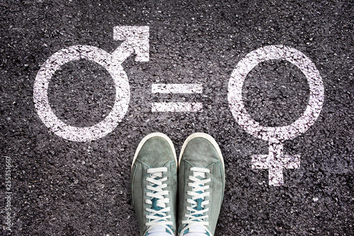 Fotografía Sneaker shoes on asphalt background with gender symbols, gender equality educati