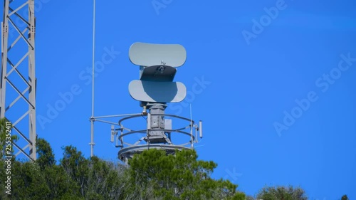 Weather radar with a rotating radiodetection antenna on top of a mountain collects weather data from whole around area