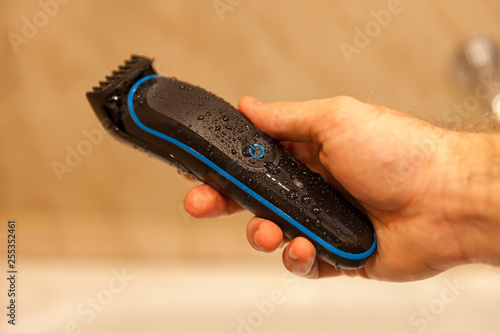 Фотография black electric razor in hand shower