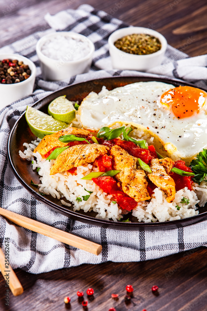 Grilled chicken meat with rice and fried egg on wooden table Grilled chicken meat with rice and fried egg on wooden table