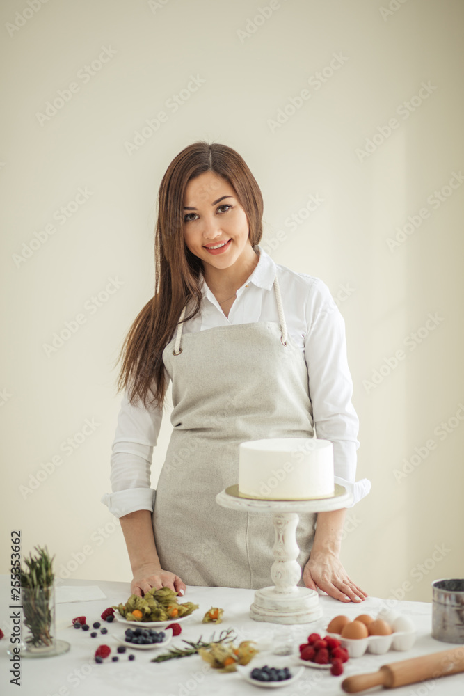 talented confectioner standing at the table and posing to the camera, close up photo. talented confectioner standing at the table and posing to the camera, close up photo.