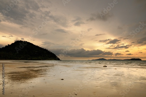 Sunset on the tropical sandy beach during low tide on the Koh Chang island in Thailand.