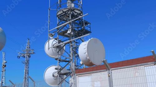 Weather radar with a rotating radiodetection antenna on top of a mountain collects weather data from whole around area. Shot in motion