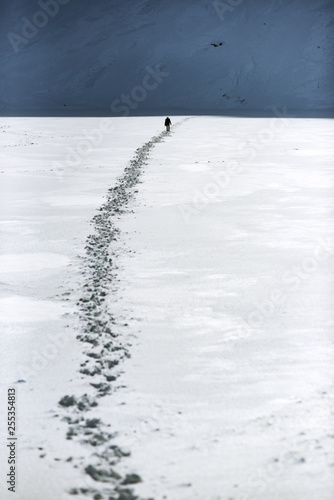 A man walking a road in the snow in the mountains. Winter mountain landscape.